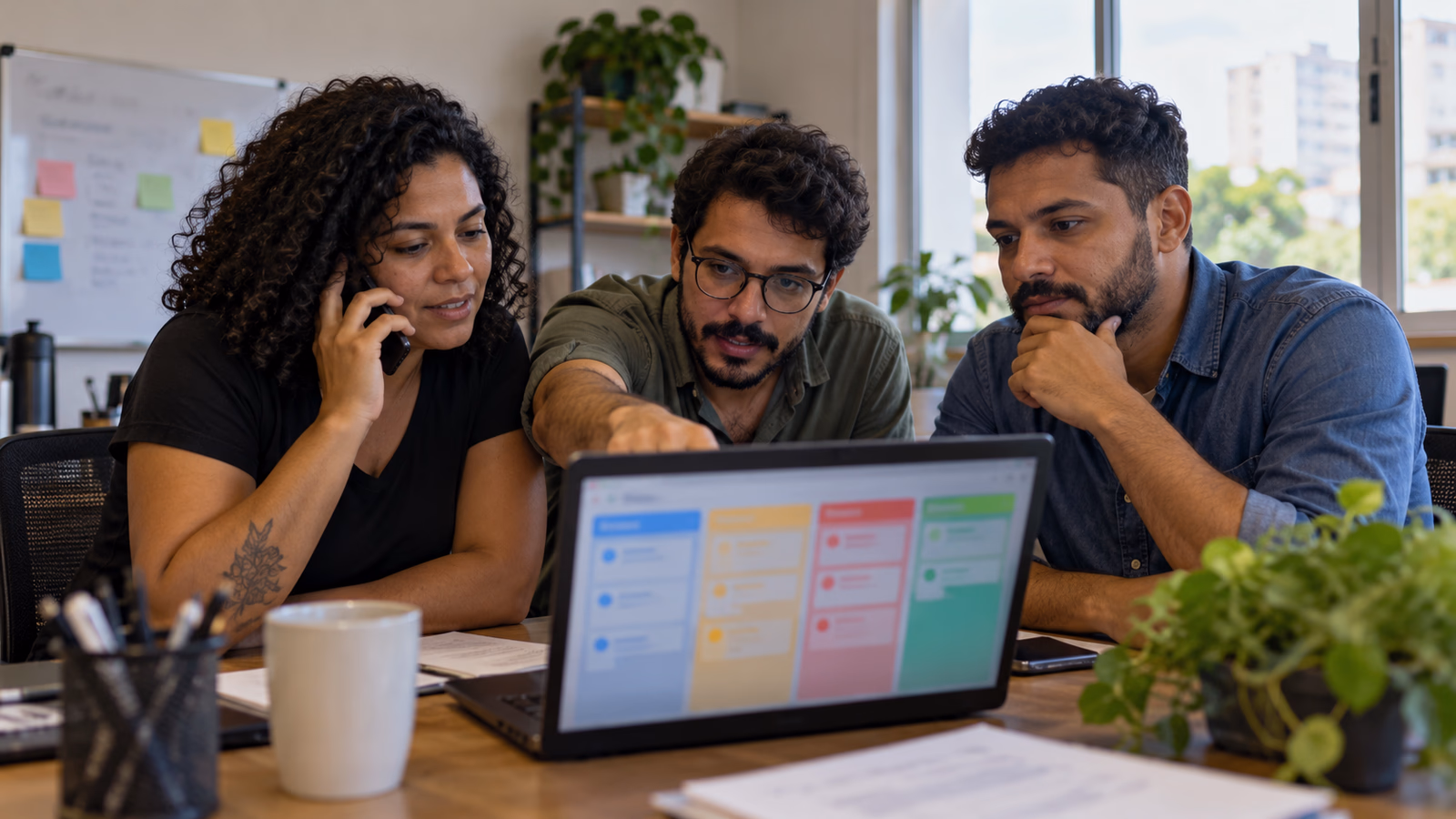 Equipe de vendas de uma pequena empresa acompanha o funil no notebook, uma pessoa ao telefone