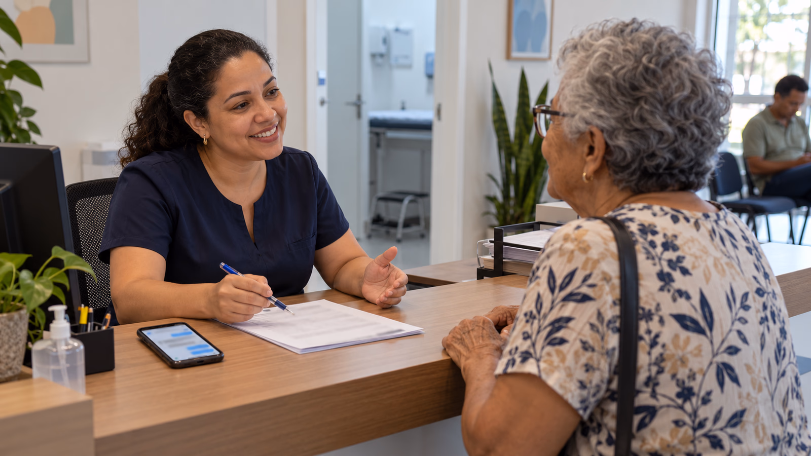 Recepcionista de consultório atende com atenção uma senhora no balcão
