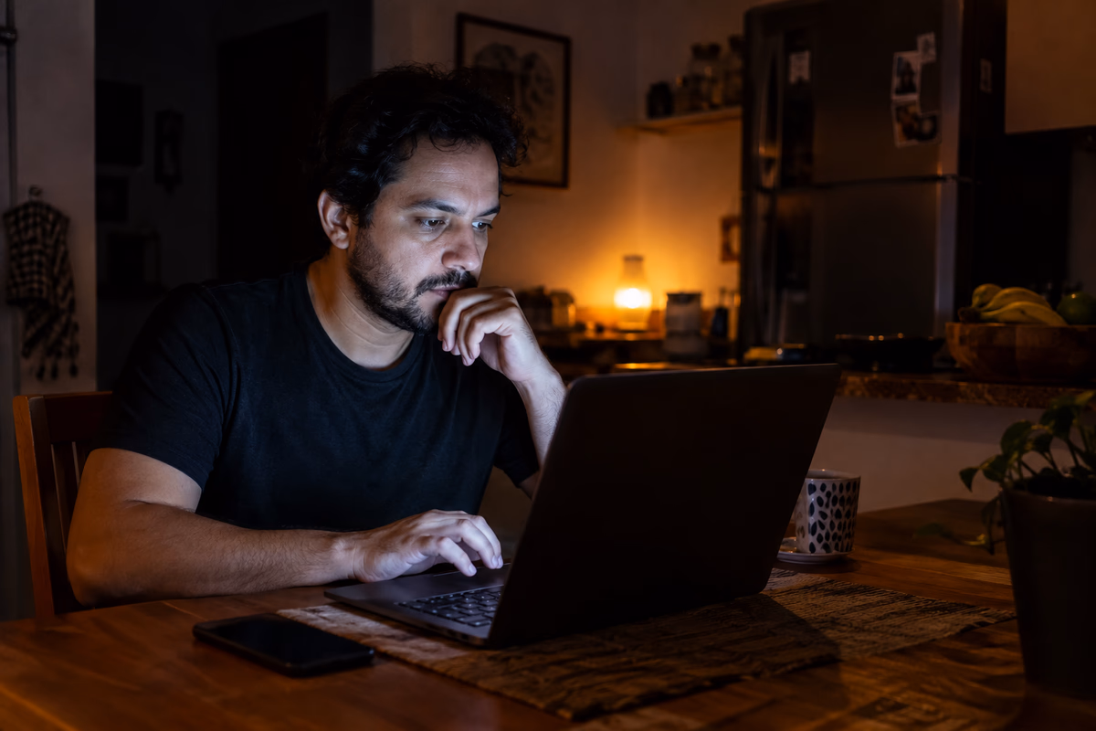 Técnico de suporte resolvendo um incidente no notebook, tarde da noite